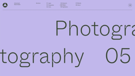 A website page with a light purple background and oversized, cropped black text reading Photography 05. A thin navigation bar at the top lists categories and a circular icon is at the top right.
