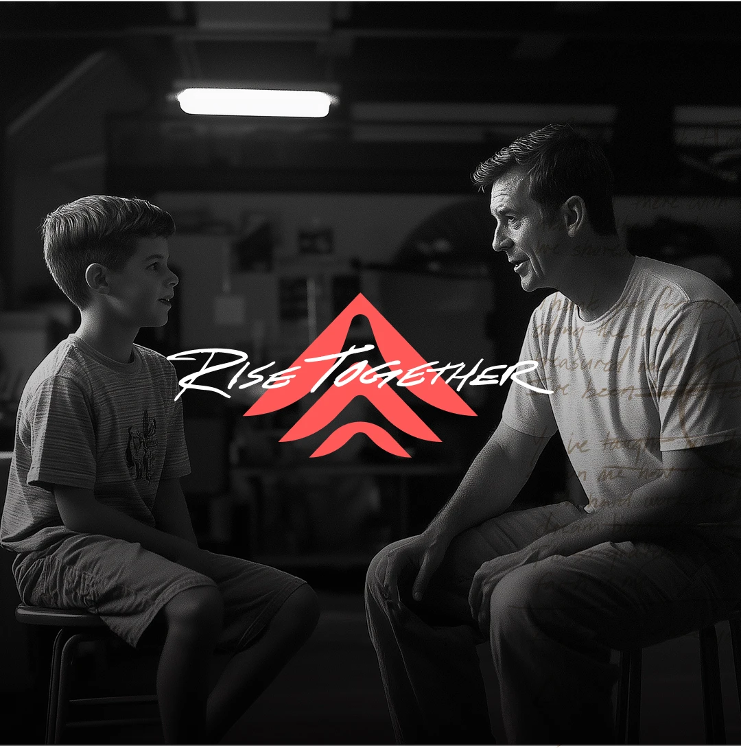 A man and a young boy sit on stools facing each other, having a conversation in a dimly lit room. The words Rise Together and a red upward arrow logo are overlaid at the center.