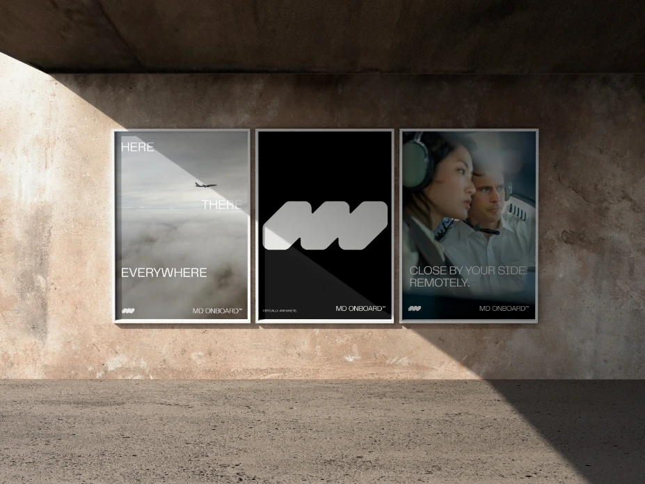 Three posters on a concrete wall: the first shows a plane above clouds with the words HERE THERE EVERYWHERE, the second has a stylized logo, and the third shows two people with headsets, reading CLOSE BY YOUR SIDE. REMOTELY.