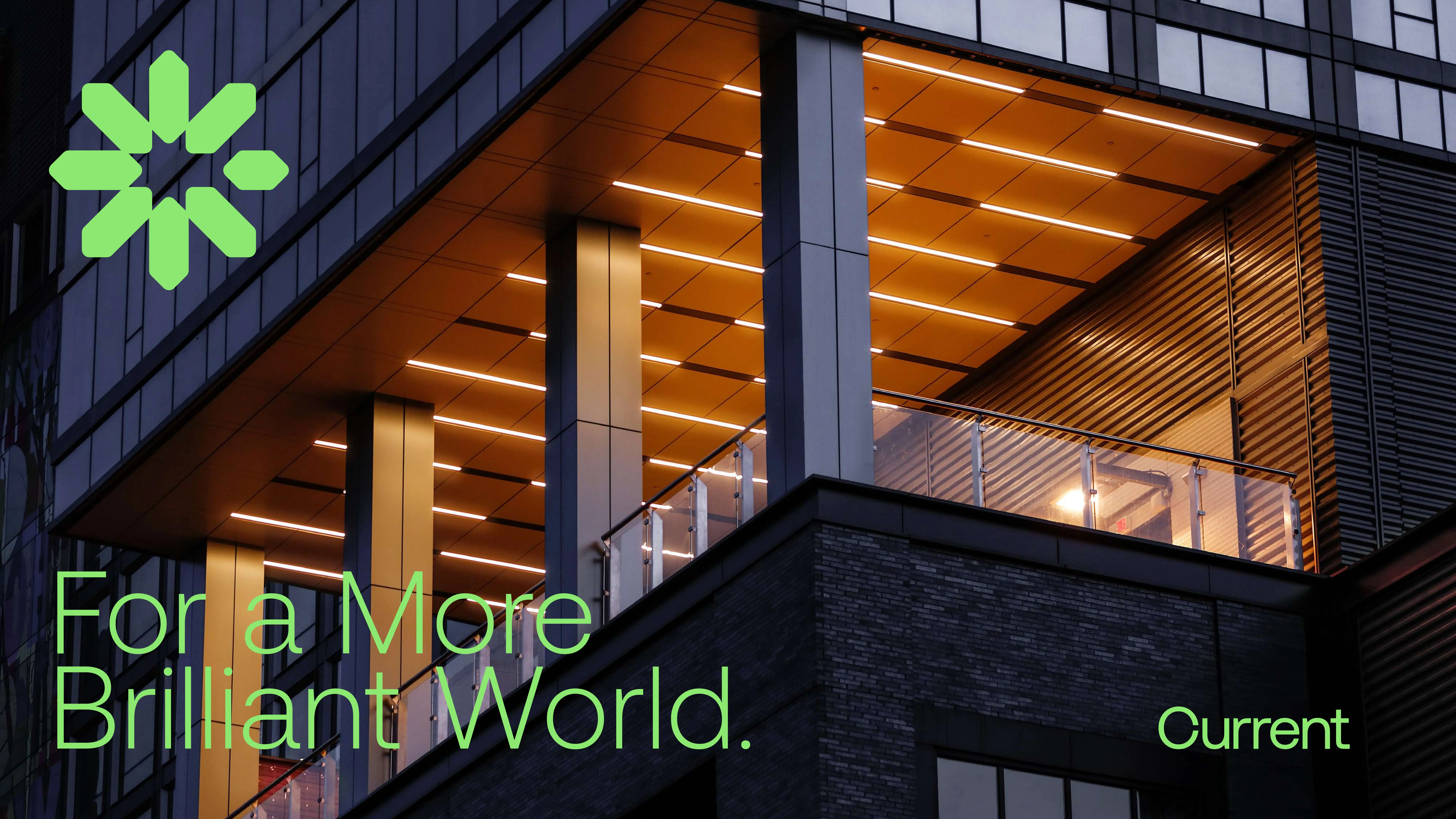 A modern building with warm, glowing lights and a grid ceiling, featuring a green geometric logo and the text For a More Brilliant World. Current in green.